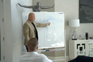 Shawn teaching at a whiteboard in an office.