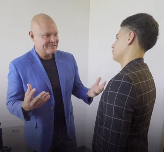 Shawn has a conversation with a colleague in an office.