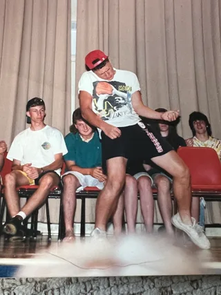 Shawn dances energetically on a stage in front of seated audience members.