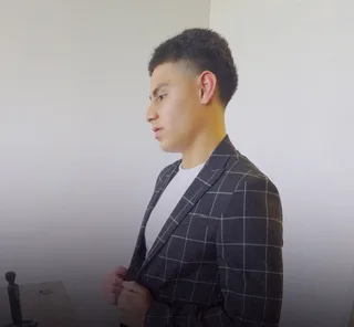 Someone adjusts a blazer in an office.