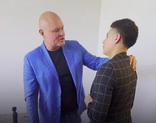 Shawn has a conversation with a colleague in an office.