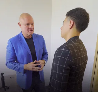 Shawn has a conversation with a client in an office.
