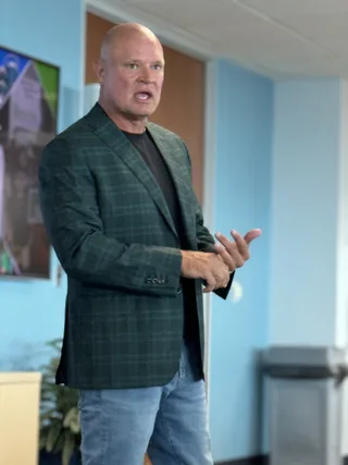 Shawn gestures with his hands while speaking in an office setting.