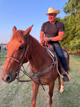 Shawn riding a horse outdoors.